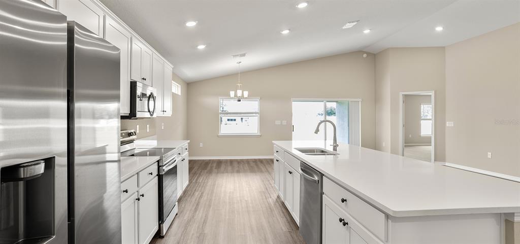 7654 Southwest 6th Loop Ocala, FL 34474 - Photo 16 of 28 a kitchen with stainless steel appliances granite countertop a sink stove and refrigerator