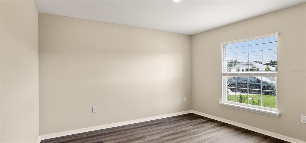 7654 Southwest 6th Loop Ocala, FL 34474 - Photo 9 of 28 an empty room with wooden floor and windows