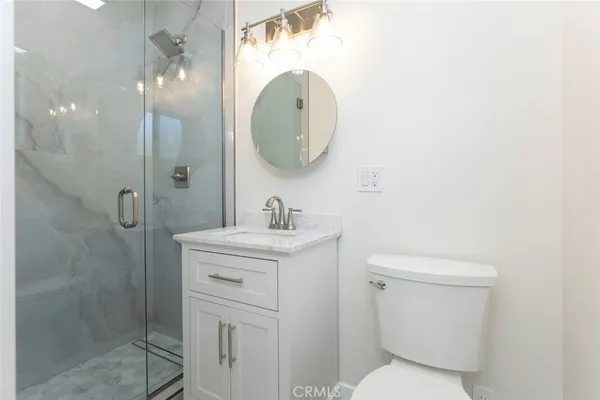 a bathroom with a toilet sink vanity and mirror