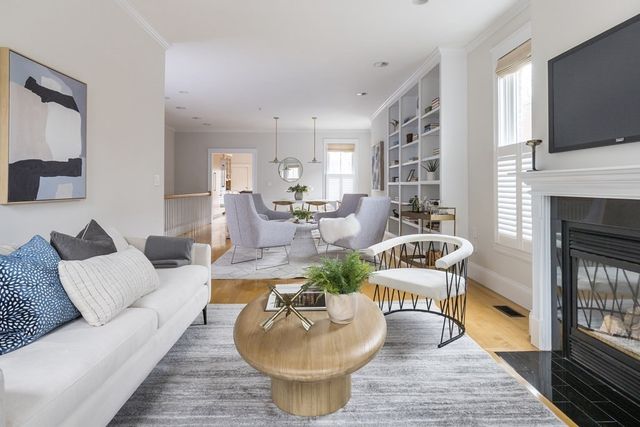 a living room with furniture a flat screen tv and a fireplace