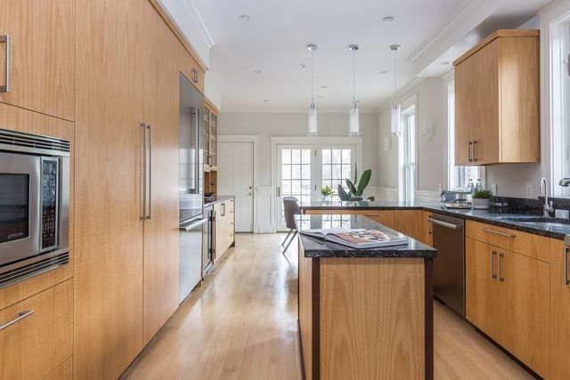 a kitchen with stainless steel appliances granite countertop a stove a sink and a refrigerator