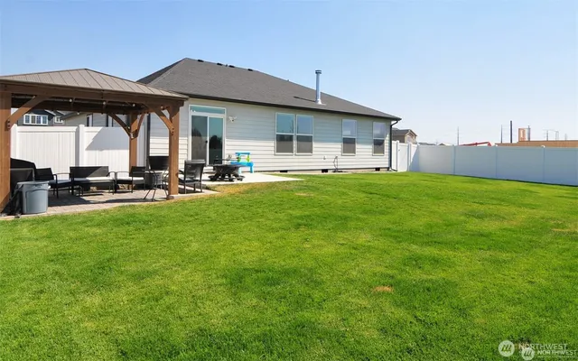 a view of a patio with table and chairs under an umbrella