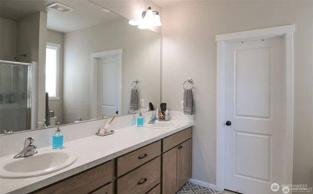 a bathroom with double vanity sink a vanity and a mirror