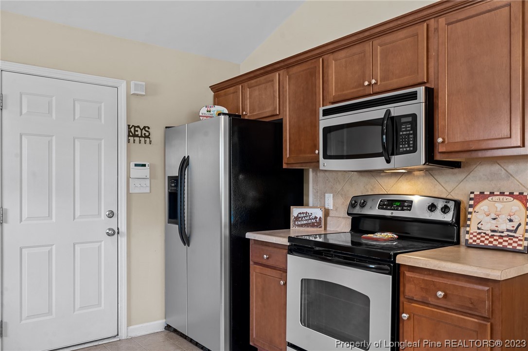 618 Valley Oak Drive Bunnlevel, NC 28323 - Photo 16 of 38 a kitchen with stainless steel appliances granite countertop a stove microwave and refrigerator