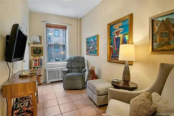 a living room with furniture a flat screen tv and a window