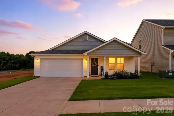 a front view of a house with a garden and yard