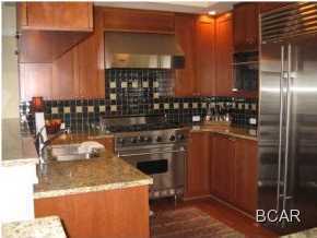 1105 Prospect Promenade, Unit 101 Panama City Beach, FL 32413 - Photo 5 of 27 a kitchen with a refrigerator and a stove