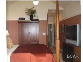 1105 Prospect Promenade, Unit 101 Panama City Beach, FL 32413 - Photo 8 of 27 a bedroom with a bed and a mirror