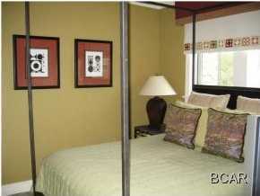 1105 Prospect Promenade, Unit 101 Panama City Beach, FL 32413 - Photo 10 of 27 a bedroom with a bed and glass wall