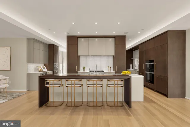 a kitchen with stainless steel appliances a sink a stove a refrigerator cabinets and wooden floor