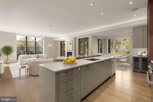 a view of a kitchen counter top space with granite countertop wooden floor and living room