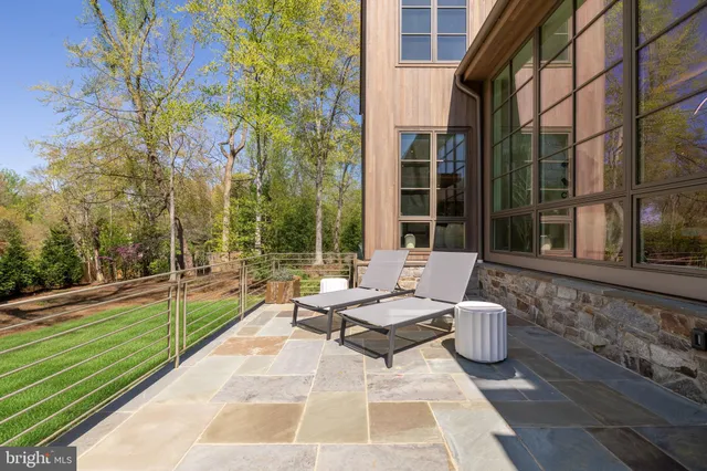 a view of a patio with couches and table and chairs with wooden fence and floor