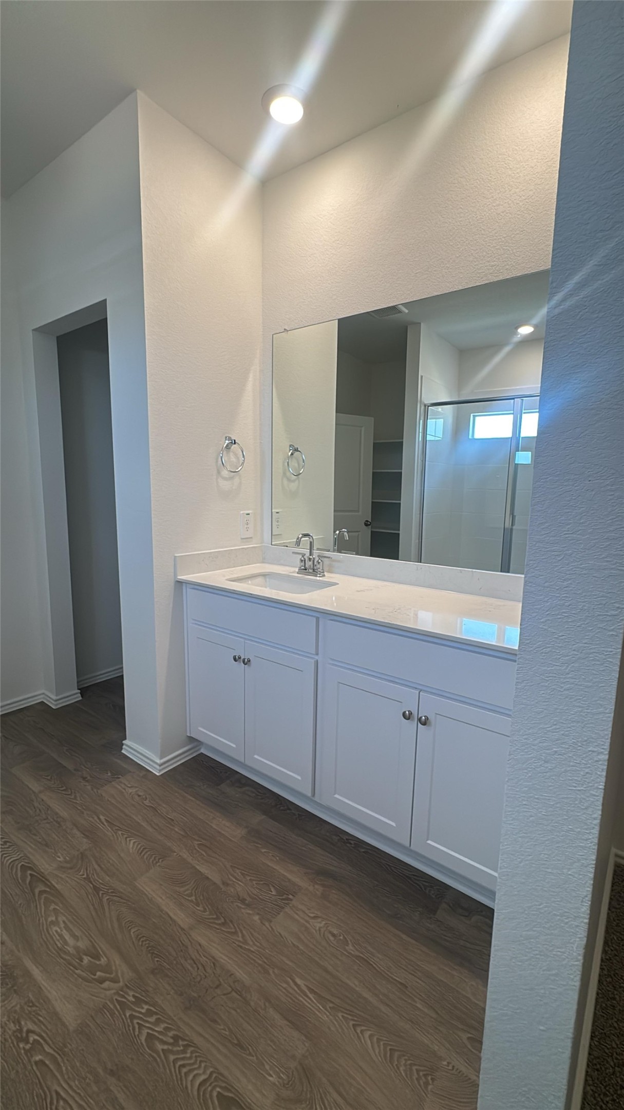 174 Balmorhea Street Kyle, TX 78640 - Photo 27 of 29 A well-lit bathroom with stylish flooring, ample cabinet space, and a generous vanity mirror.