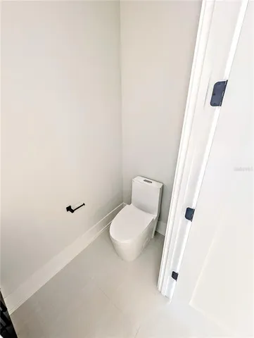a white toilet sitting next to a white cabinet