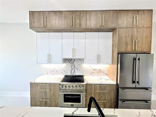 a kitchen with granite countertop a stove and a refrigerator with cabinets