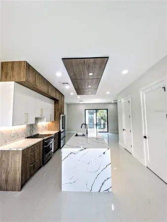 a large white kitchen with a large window