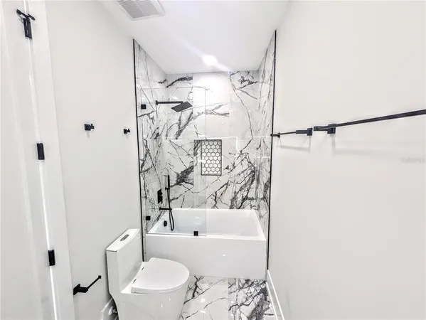 a bathroom with a toilet and a shower