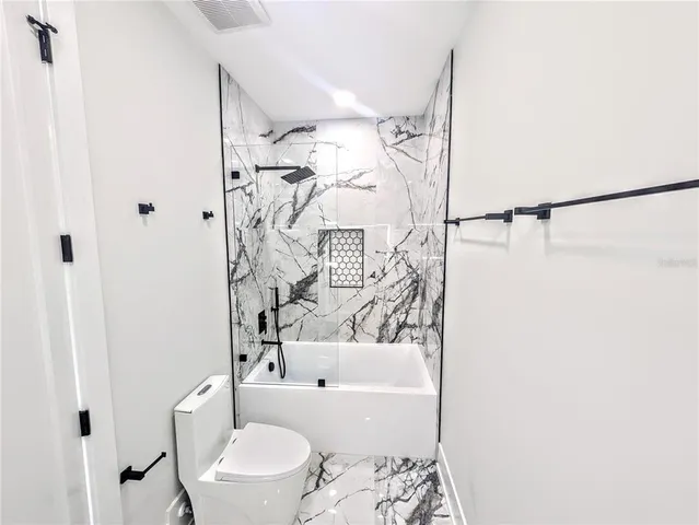 a bathroom with a toilet and a shower