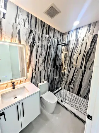 a bathroom with a sink a toilet and a mirror