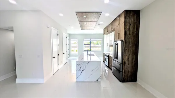 a view of a hallway with windows and chandelier