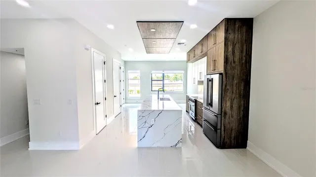 a view of a hallway with windows and chandelier