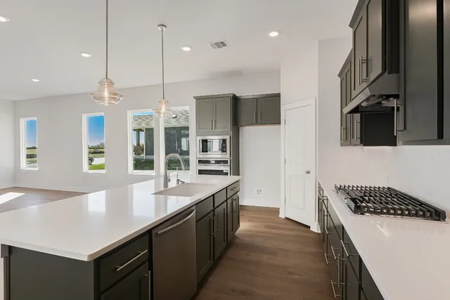 a kitchen with stainless steel appliances a sink stove and refrigerator