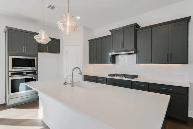 a kitchen with stainless steel appliances a stove a sink and a refrigerator