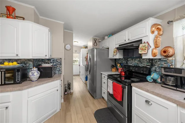 a kitchen with a refrigerator and a stove top oven
