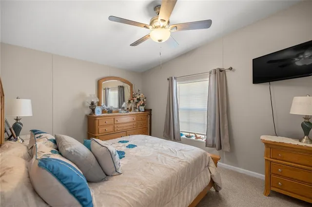 a bedroom with a bed a dresser and flat screen tv