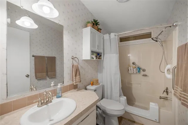 a bathroom with a sink toilet and shower