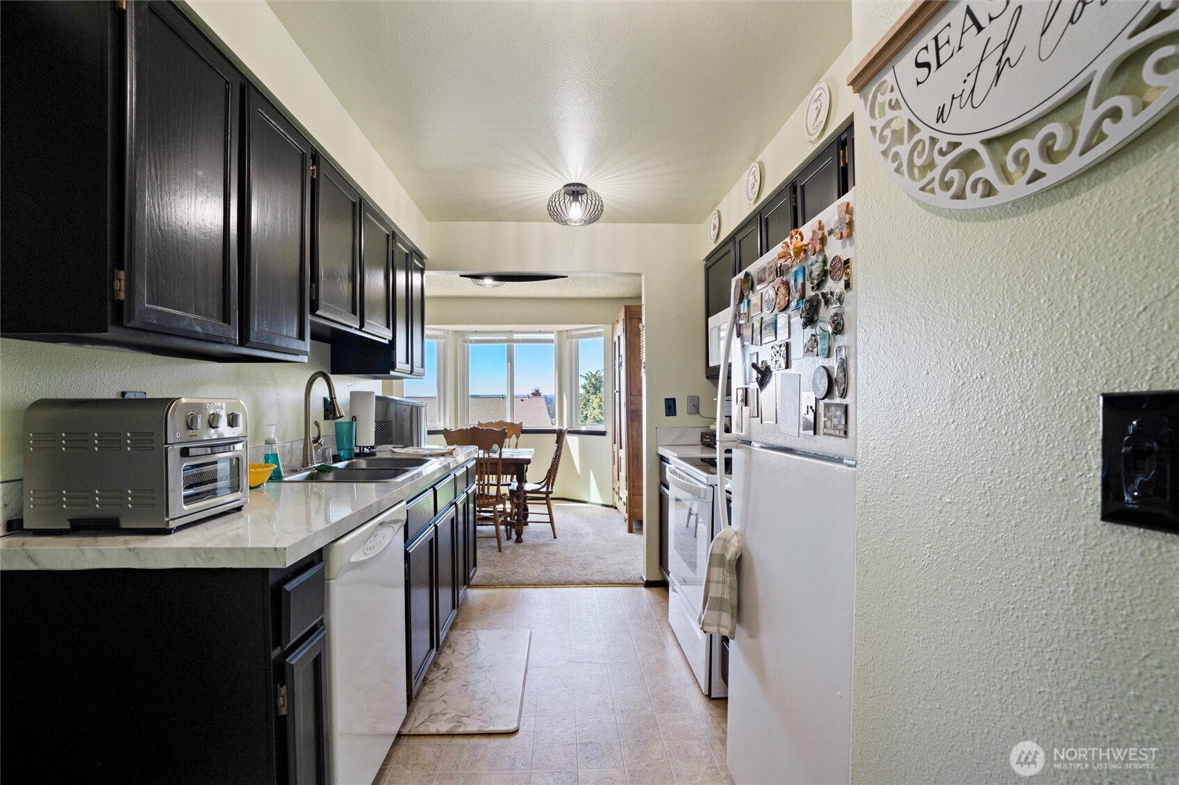 3560 Narrows View Lane Northeast, Unit 202 Bremerton, WA 98310 - Photo 6 of 27 a kitchen with stainless steel appliances granite countertop a refrigerator and a stove top oven