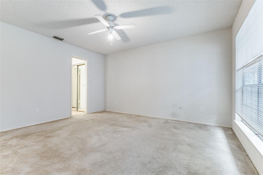 5981 Arapaho Road, Unit 1106 Dallas, TX 75248 - Photo 8 of 12 an empty room with chandelier fan and windows