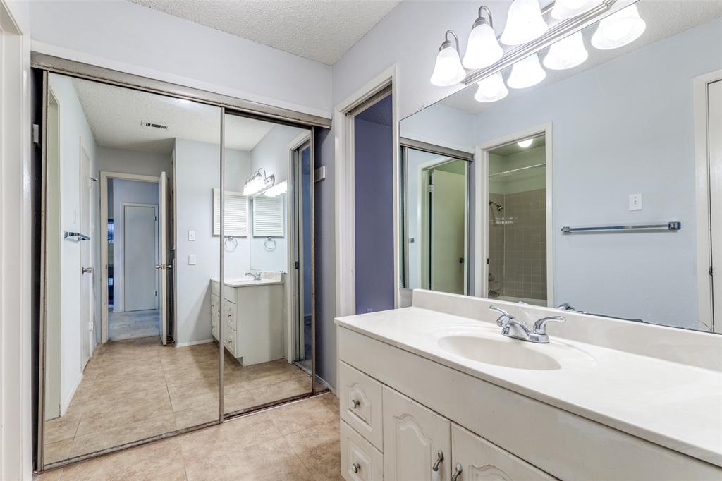 5981 Arapaho Road, Unit 1106 Dallas, TX 75248 - Photo 9 of 12 a bathroom with a sink a mirror and a shower