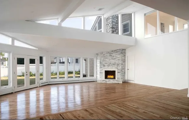 a view of empty room with fireplace and wooden floor
