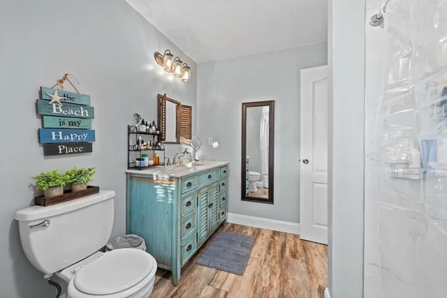 a bathroom with a sink vanity granite toilet and shower