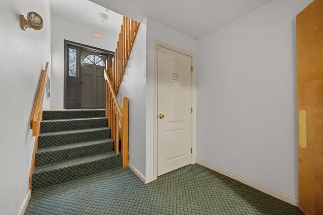 a view of a hallway with entryway and stairs