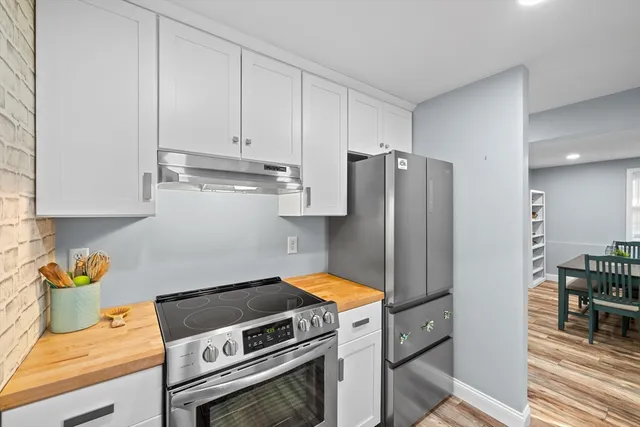 a kitchen with stainless steel appliances granite countertop a refrigerator and a stove