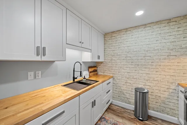 a kitchen with granite countertop white cabinets and wooden floor