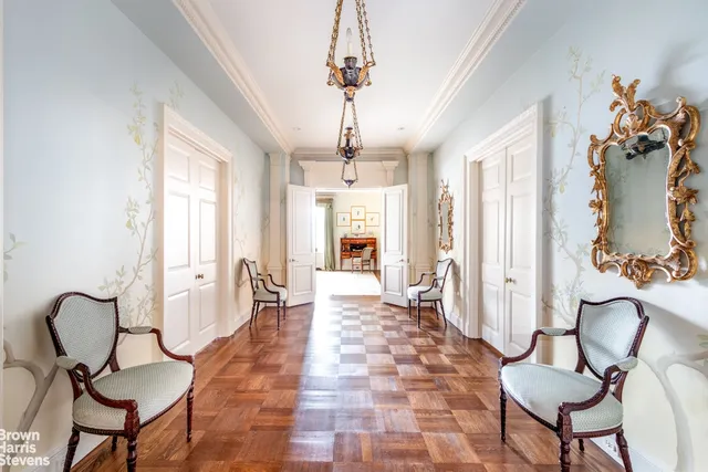 a living room with furniture a fireplace and a chandelier