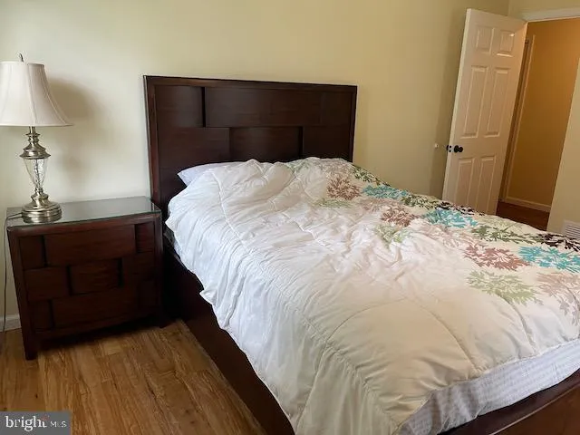 a bed sitting in a bedroom and wooden floor