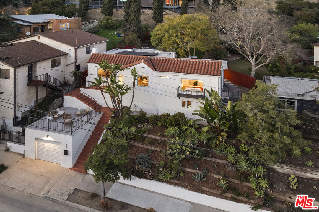 an aerial view of a house with garden space and street view