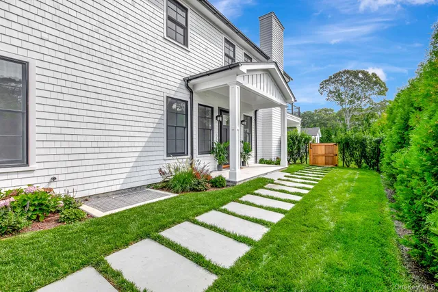 a kitchen with stainless steel appliances granite countertop a stove a refrigerator a sink and white cabinets with wooden floor