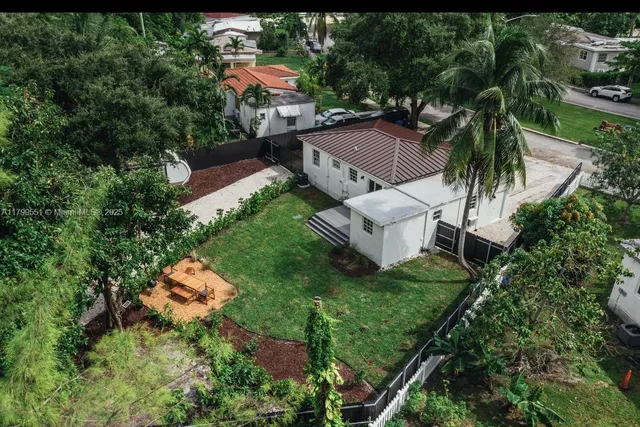 an aerial view of residential house with outdoor space and trees all around