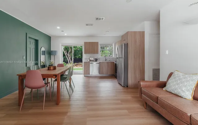 a living room with furniture wooden floor and a refrigerator