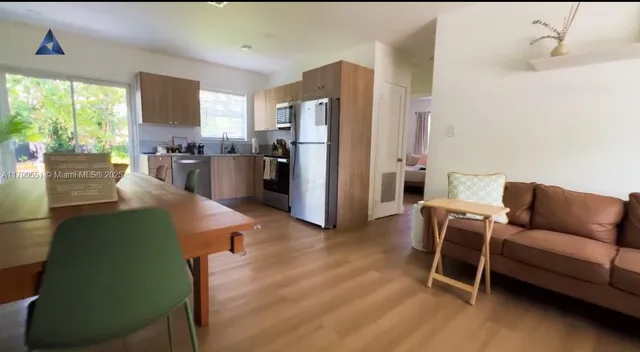 a living room with furniture wooden floor and a large window
