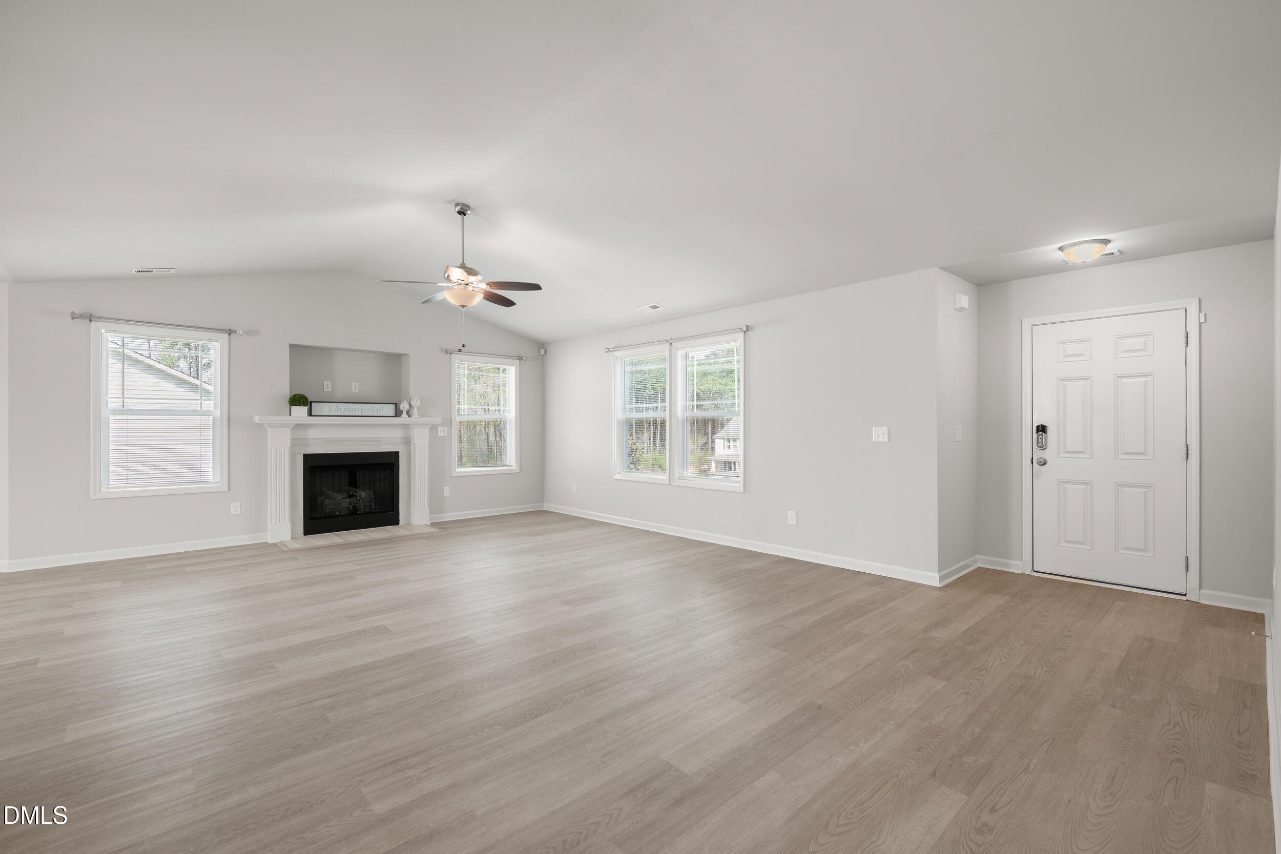 67 Dale Ridge Drive Princeton, NC 27569 - Photo 4 of 22 an empty room with wooden floor fireplace and windows