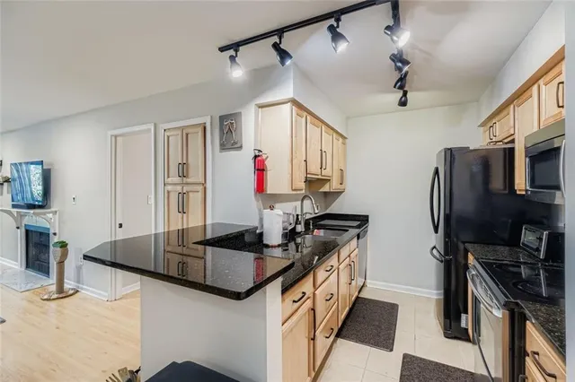 a kitchen with granite countertop a sink appliances and cabinets
