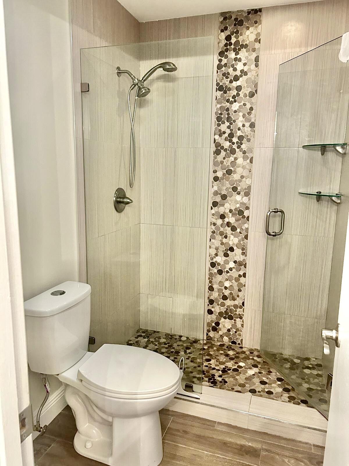 2811 Southwest 15th Street, Unit 202 Delray Beach, FL 33445 - Photo 17 of 21 a bathroom with a toilet and shower