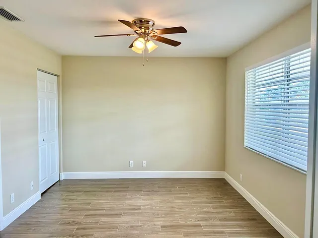a view of a room with wooden floor and a ceiling fan