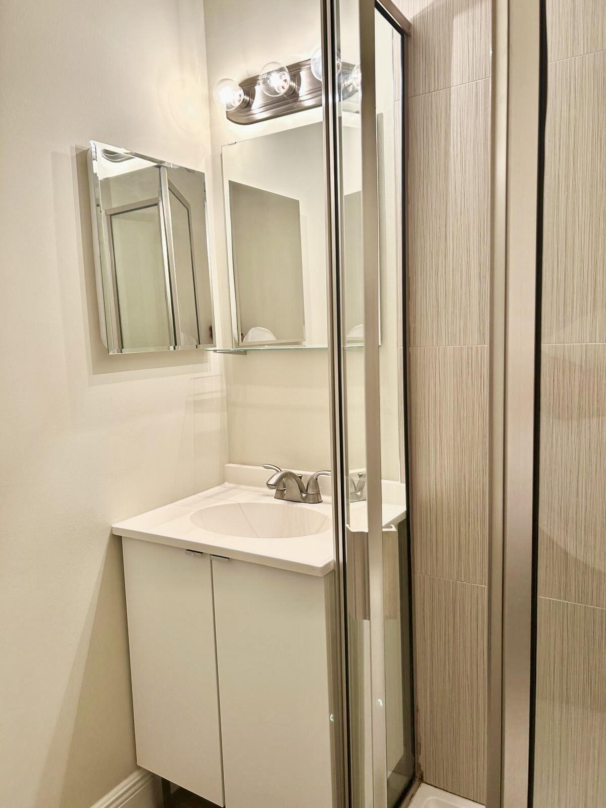 2811 Southwest 15th Street, Unit 202 Delray Beach, FL 33445 - Photo 20 of 21 a bathroom with a sink and a mirror